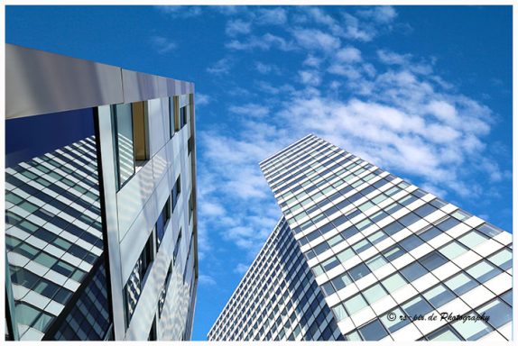 Hohe moderne Gebäude mit Glasfassaden unter blauem Himmel.